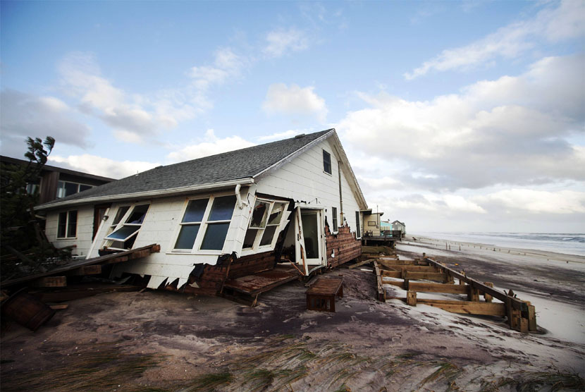 Sebuah rumah yang rusak akibat Badai Sandy di Fire Island, New York, Selasa (30/10).  (Lucas Jackson/Reuters)