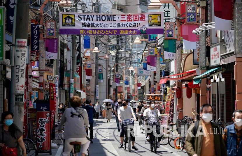 Sebuah spanduk imbauan agar orang-orang tinggal di rumah untuk menekan penyebaran COVID-19 dan pandemi coronavirus di kawasan pertokoan, Tokyo, Jepang