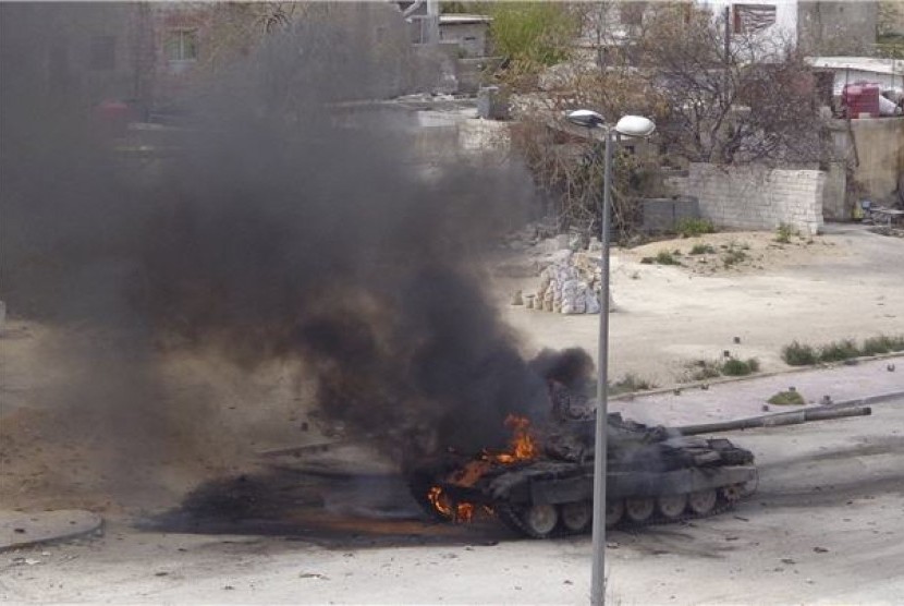 Sebuah tank milik pemerintah Suriah terbakar dalam peperangan lawan Tentara Pembebasan Suriah (FSA) di Damaskus pada Selasa (19/3). 