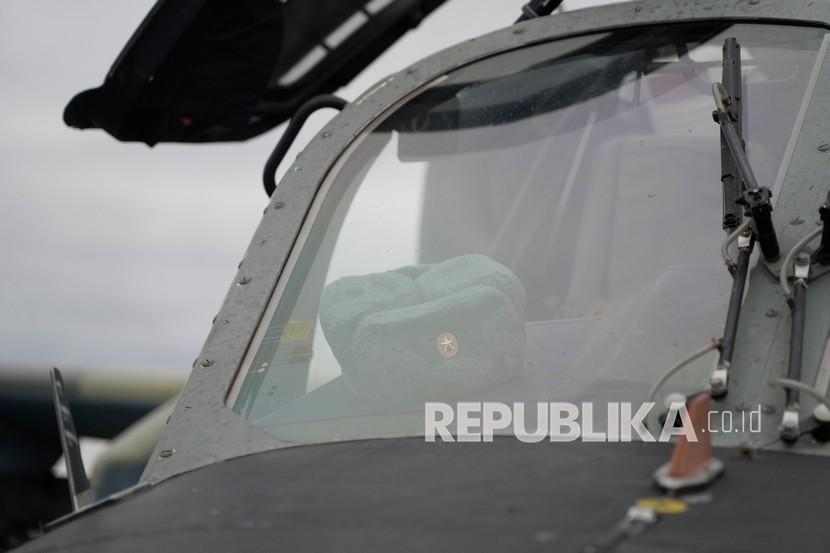  Sebuah topi militer terlihat melalui jendela helikopter tempur Ka-52 Rusia terlihat di lapangan setelah pendaratan paksa di luar Kyiv, Ukraina, Kamis, 24 Februari 2022. Rusia mengklaim telah menonaktifkan 90 persen lapangan udara militer Ukraina