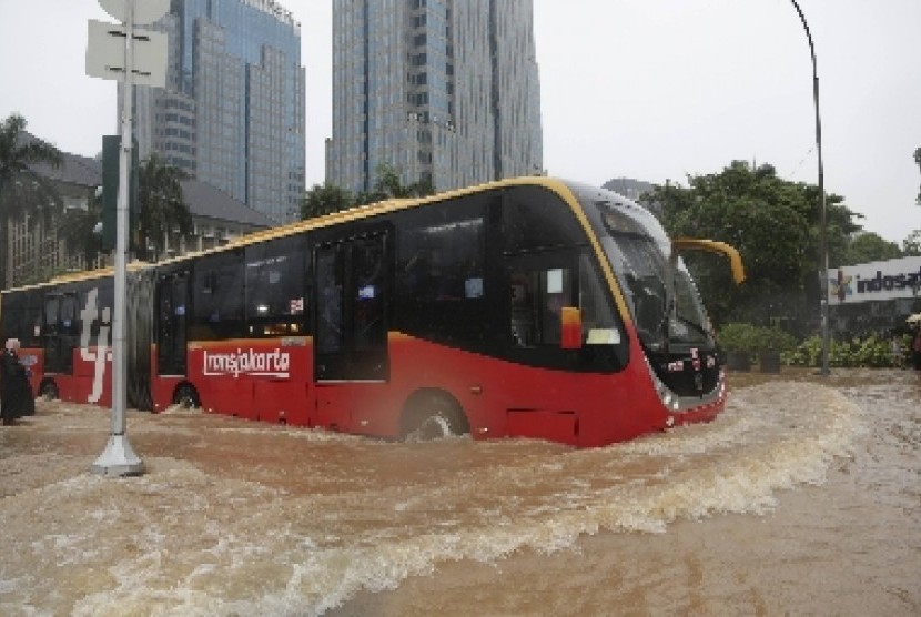 Sebuah Transjakarta menerobos banjir di Jakarta, Senin (9/2).