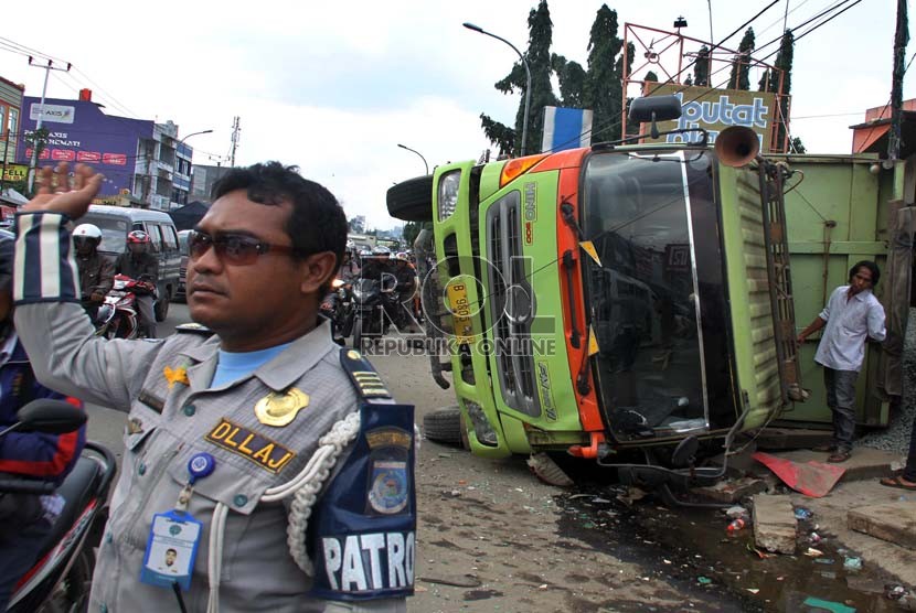    Sebuah truk bermuatan batu koral terguling di Jalan Raya Ciputat, Tangerang Selatan, Rabu (28/11).   (Republika/Yasin Habibi)