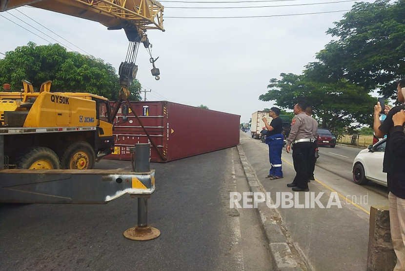 Sebuah truk fuso kontainer terguling dengan posos melintang usai menabrak pagar rumah warga di jalur utama pantura Indramayu, tepatnya di Desa Jumbleng, Kecamatan Losarang, Selasa (26/11/2024). 