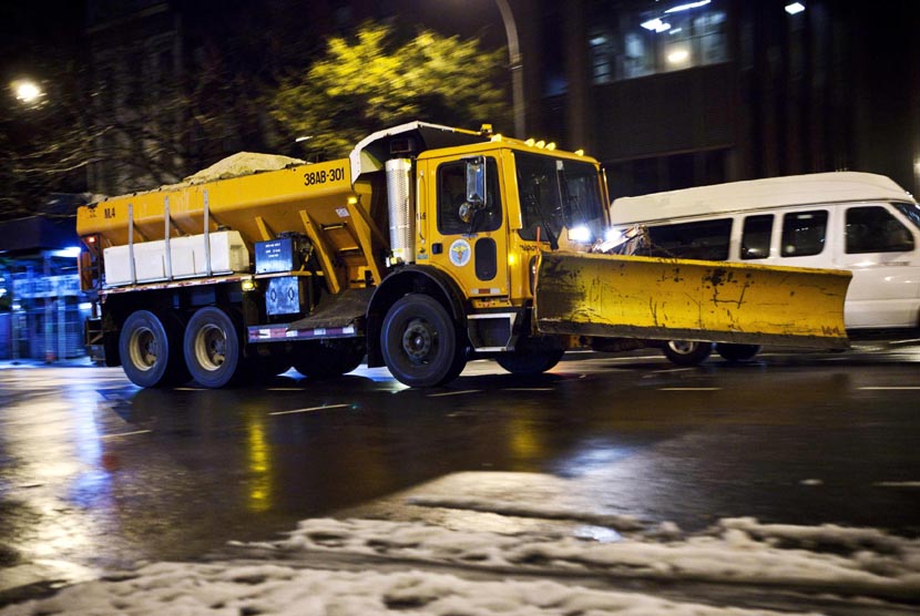  Sebuah truk membersihkan salju yang menutupi jalan di kawasan Lower East Side di New York, Rabu (8/11). (Reuters/Andrew Burton) 