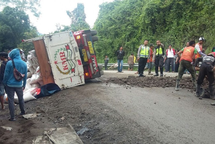 Sebuah truk terbalik di ruas Jalan Raya Bandung-Cirebon KM 68, Kecamatan Tomo, Kabupaten Sumedang yang amblas pada Senin (20/3), pagi. 