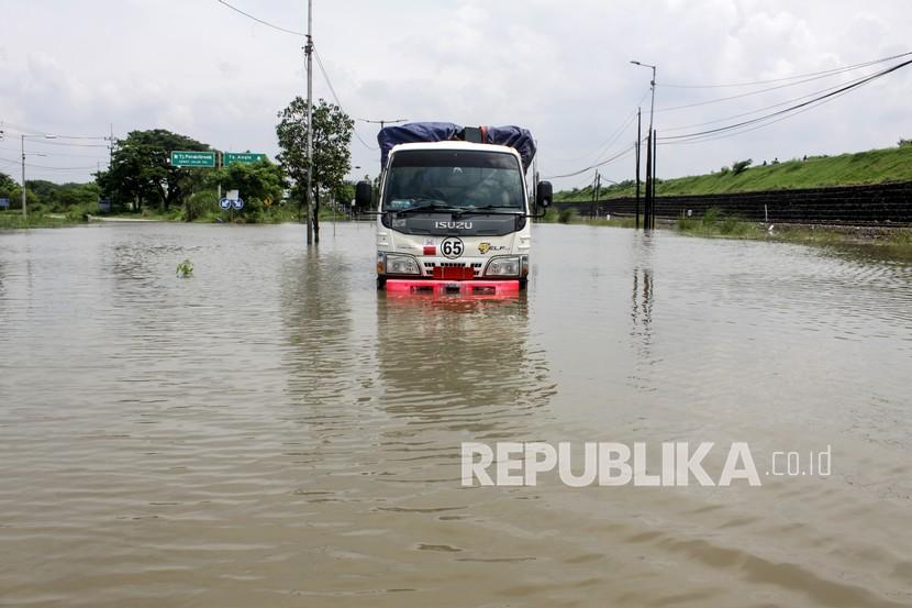 Sebuah truk terjebak banjir di jalan raya Porong, Sidoarjo, Jawa Timur, Senin (18/1/2021). Curah hujan yang tinggi sejak Minggu (17/1) malam mengakibatkan banjir yang merendam Jalan Raya Porong sehingga mengganggu kelancaran transportasi umum.
