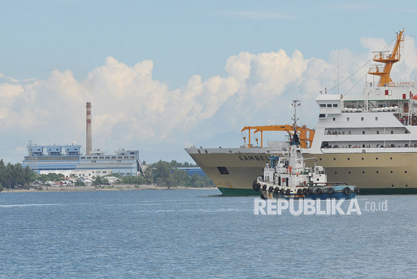 Sebuah tugboat dan kapal penumpang melintas dengan latar Pembangkit Listrik Tenaga Uap (PLTU) Mpanau di Kecamatan Tawaili, Palu Utara, Sulawesi Tengah, Sabtu (23/6).