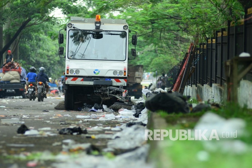 Sebuha mobil penyapu jalanan membersihkan sampah yang ditinggalkan para pedagang usai pasar tumpah, di jalan seputar taman Monumen Perjuangan Jabar, Kota Bandung, Ahad (6/11).