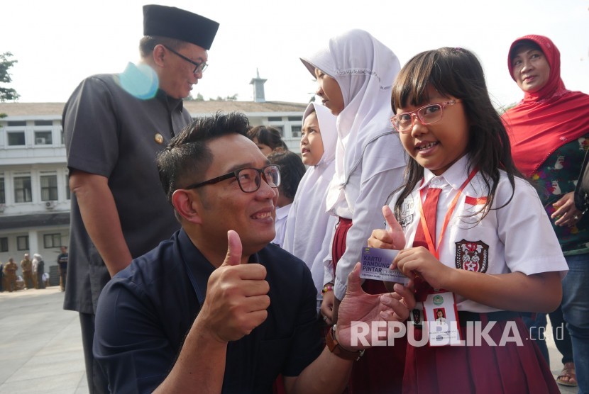 Secara simbolis Wali Kota Bandung Ridwan Kamil menyerahkan kartu Bandung Juara kepada sejumlah siswa, di Plaza Balai Kota Bandung, Senin (24/7).