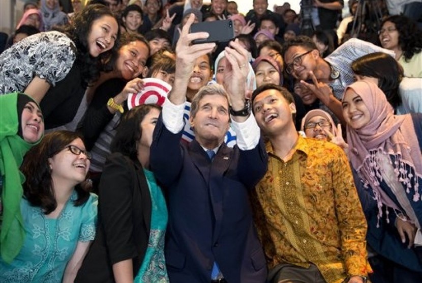 Secretary of State John Kerry (center) takes a selfie with a group of students before delivering a speech on climate change on Sunday, Feb. 16, 2014, in Jakarta, Indonesia. 