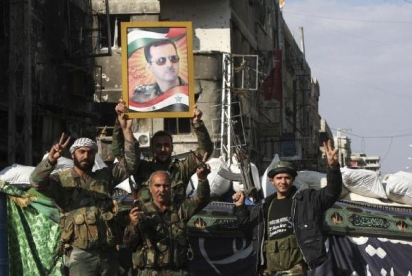 Security personnel loyal to Syria's President Bashar al-Assad flash the 'V' signs in Hujaira town, south of Damascus November 20, 2013 file photo.  