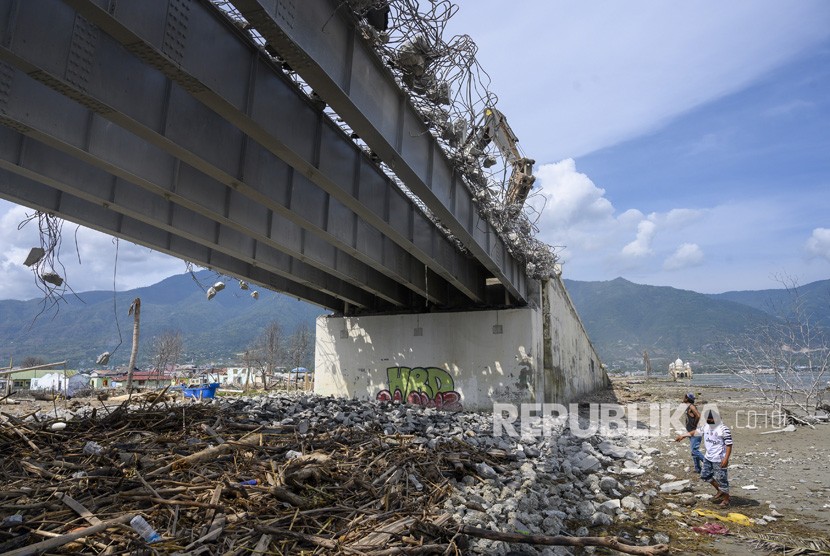 Sejumlah pekerja mengumpulkan besi-besi rangka Jembatan Palu IV yang dirobohkan di Pantai Kampung Lere, Palu, Sulawesi Tengah, Rabu (11/12/2019).
