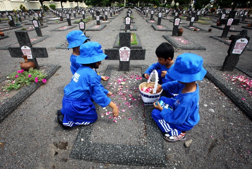 Sejumah pelajar dari TK Model Sleman menaburkan bunga ke pusara makam pahlawan kemerdekaan saat berziarah di Taman Makam Pahlawan (TMP) Kusumanegara, Yogyakarta, Selasa (10/11).