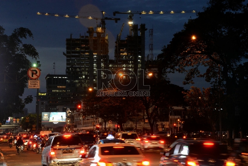 Sejumalah kendaraan melintas dengan latar belakang pembangunan gedung bertingkat di Jakarta, Selasa (5/5).  (Republika/Prayogi)