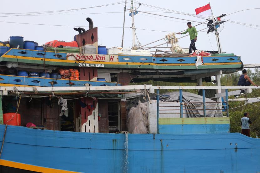 Sejumlah ABK beraktivitas di atas kapal nelayan yang bersandar di muara sungai Karangsong, Indramayu, Jawa Barat, Sabtu (13/11/2021). Sejak dua pekan terakhir, ratusan kapal nelayan di daerah itu tidak melaut karena cuaca buruk juga biaya perbekalan yang semakin mahal. 