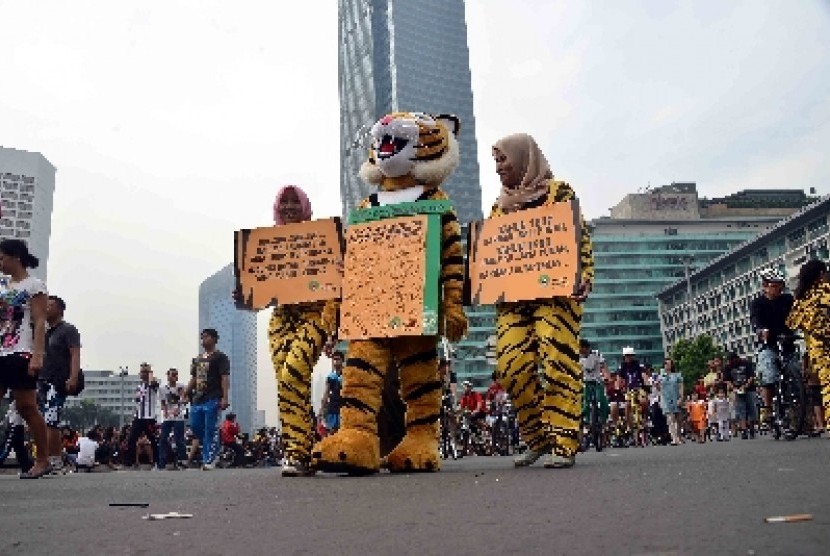 Sejumlah aktivis Greenpeace mengenakan pakaian harimau berjalan untuk mengkampanyekan perlindungan Harimau Sumatera di Bundaran HI, Jakarta, Ahad (8/12). Para aktivis mengajak masyarakat untuk ikui mendukung gerakan penyelamatan Harimau Sumatera yang saat 