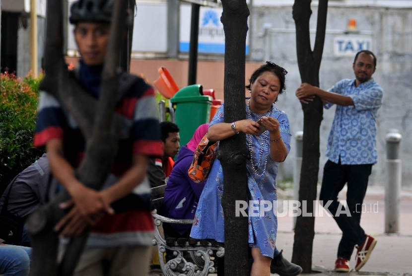 Sejumlah aktivis melakukan aksi peluk pohon di trotoar Jalan Jenderal Sudirman, Jakarta Pusat, Jumat (22/9).