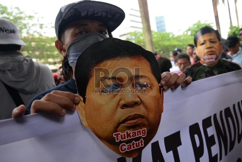 Sejumlah aktivis memakai topeng Ketua DPR Setya Novanto saat berunjuk rasa di depan Gedung Komisi Pemberantasan Korupsi (KPK), Jakarta, Selasa (24/11). 