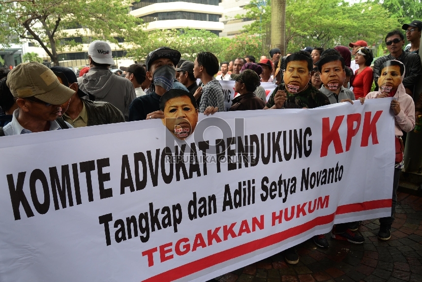 Sejumlah aktivis memakai topeng Ketua DPR Setya Novanto saat berunjuk rasa di depan Gedung Komisi Pemberantasan Korupsi (KPK), Jakarta, Selasa (24/11).