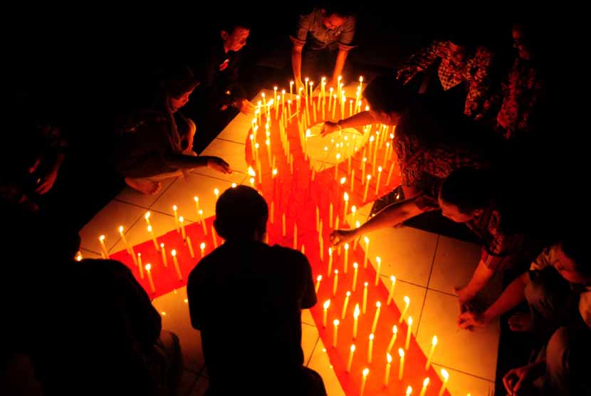 Sejumlah aktivis menyalakan lilin pada malam renungan HIV/AIDS. 