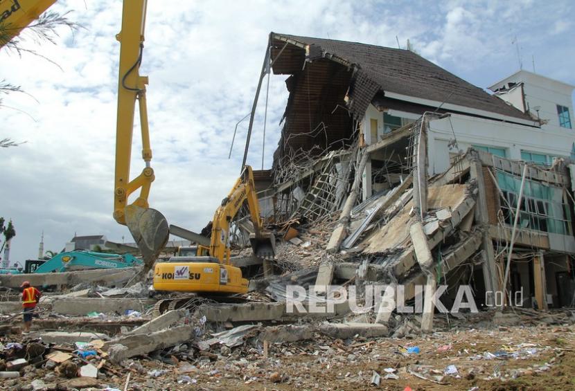 Memasuki hari keenam Pasca gempa bumi sebagian bangunan yang terdapak kerusakan berat kini mulai dibersihkan menggunakan alat berat. 