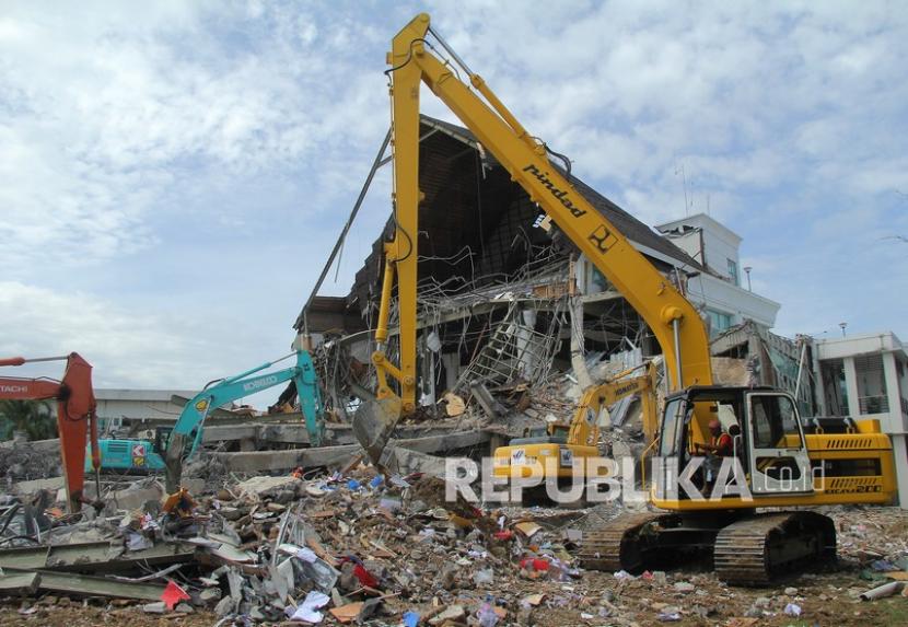 Sejumlah alat berat membersihkan puing reruntuhan bangunan kantor gubernur Sulbar, Mamuju, Sulawesi Barat, Rabu (20/1/2021). Hasil analisis BMKG menunjukkan, gempa bumi pada Kamis (21/1) malam memiliki magnitudo 4.0.