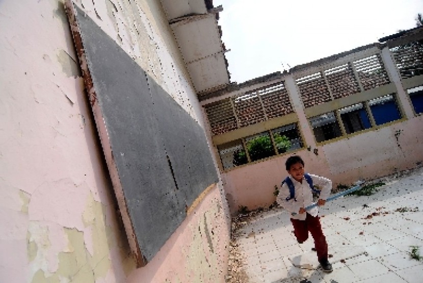 Sejumlah anak-anak bermain di ruang kelas di SDN 06 Malaka Jaya, Duren Sawit, Jakarta Timur yang tanpa atap dan rusak, Jumat (27/4). 