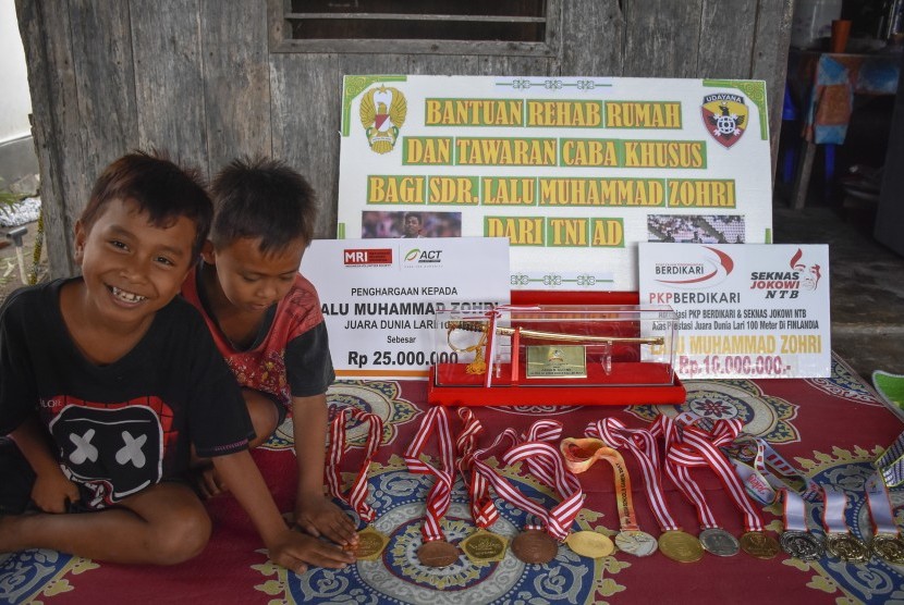 Sejumlah anak-anak melihat medali milik pelari Lalu Muhammad Zohri di rumahnya di Dusun Karang Pangsor, Pemenang Barat, Pemenang, Tanjung, Lombok Utara, NTB, Jumat (13/7).