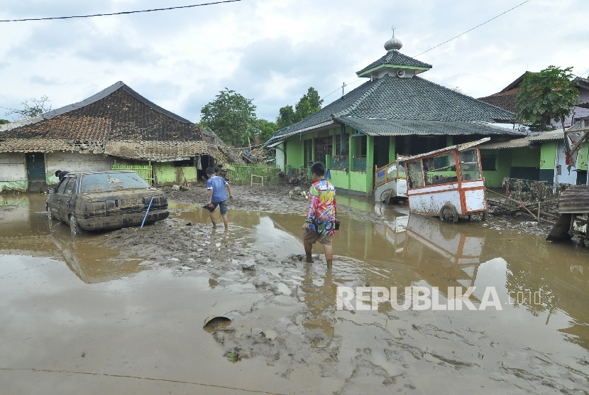 Sejumlah anak-anak melintas di Kampung Cimacan pasca banjir bandang, Kecamatan Tarogong Kidul, Kabupaten Garut, Rabu (21/9).