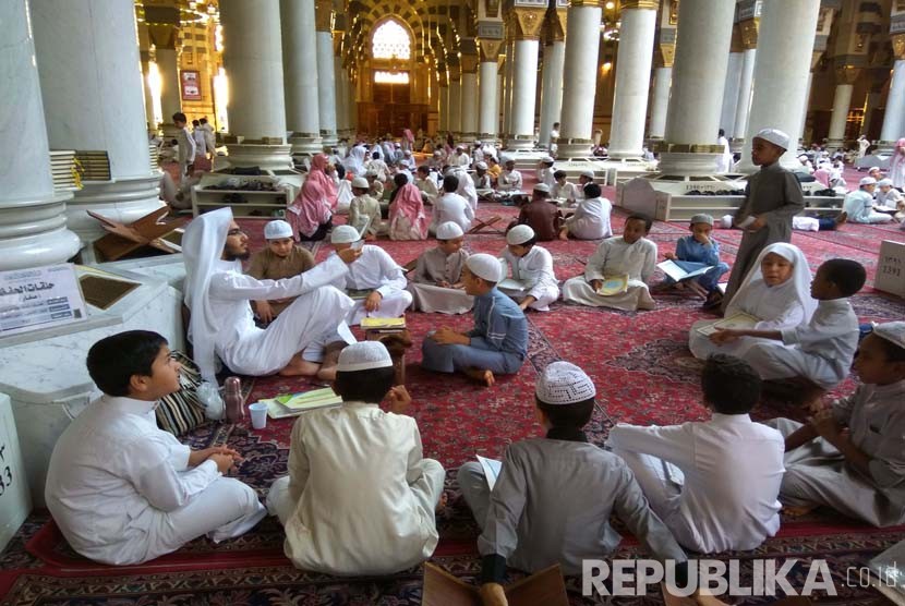 Sejumlah anak-anak tengah muroja'ah (mengulang hafalan) alquran dibimbing oleh seorang guru di masjid Nabawi.