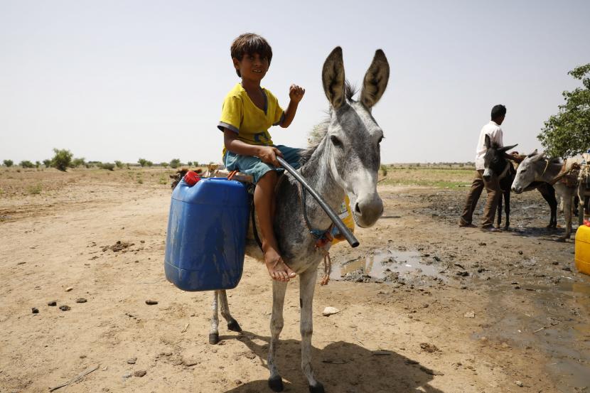 Sejumlah Anak-anak Yaman menunggu giliran mengisi jerigen dengan selang dari sumur pompa bertenaga diesel di kota Abs, provinsi Hajjah, Yaman, Selasa (8/9). FAO mengungkap sepertiga dari 420 juta populasi negara Arab alami kurang gizi. Ilustrasi.