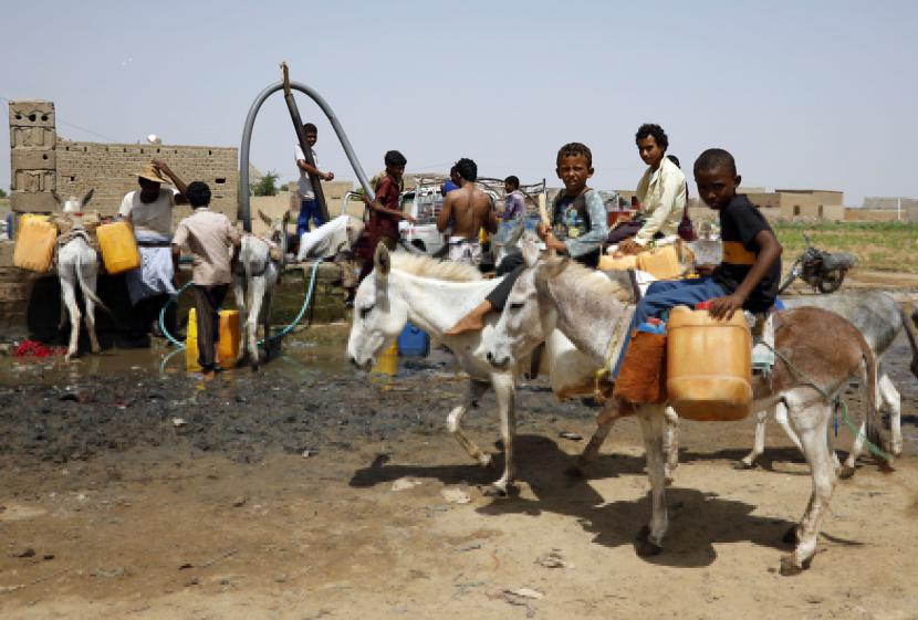 Sejumlah Anak-anak Yaman menunggu giliran mengisi jeriken dengan selang dari sumur pompa bertenaga diesel di kota Abs, provinsi Hajjah, Yaman, Selasa (8/9). Banyak anak laki-laki Yaman meninggalkan rumah mereka dengan membawa keledai dan tabung air plastik untuk mengambil air dari sumur Abs, beberapa jam dari desa mereka. Bepergian jauh untuk mengambil air untuk keluarga setiap hari membuat anak laki-laki tersebut tidak bersekolah. Ribuan keluarga Yaman di daerah itu kebanyakan bergantung pada anak-anak mereka untuk mengambil air untuk minum, memasak dan mencuci. Menurut UNICEF, hampir 18 juta orang dari 29 juta penduduk Yaman, termasuk 9,2 juta anak-anak, tidak memiliki akses reguler ke air bersih. Awal Tahun 2022, Perang Yaman Renggut Nyawa 17 Anak