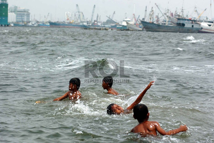  Sejumlah anak berenang di pinggiran Pantai Muara Baru yang penuh dengan limbah kapal laut, Jakarta Utara, Senin (8/9). (Republika/Raisan Al Farisi)