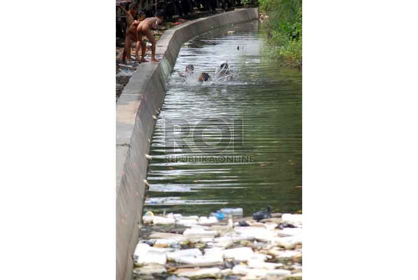 Sejumlah anak bermain air di sungai kecil kawasan Kampung Bandan, Jakarta Utara, Selasa (22/7). (Republika/Raisan Al Farisi).