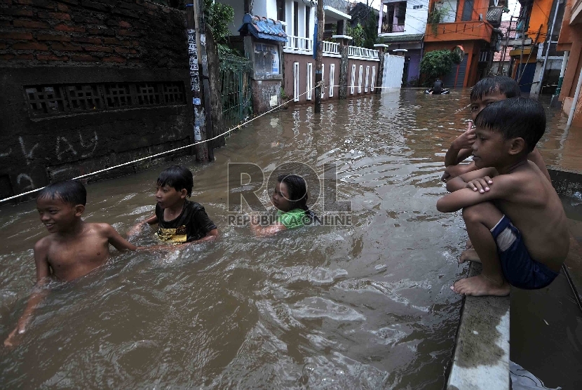Sejumlah anak bermain air ketika banjir merendam di Petogogan, Jakarta Selatan, Selasa (10/2).(Republika/Agung Supriyanto)