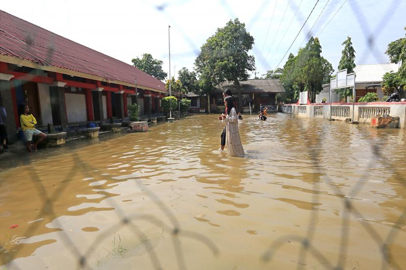 Sejumlah anak bermain air saat banjir menggenangi SDN 02 Pranggong, Kecamatan Arahan, Indramayu, Jawa Barat, Senin (18/7/2022). Pihak sekolah terpaksa meliburkan siswanya pada hari pertama masuk sekolah karena sejumlah ruang kelas terendam banjir akibat luapan sungai Cipelang. 