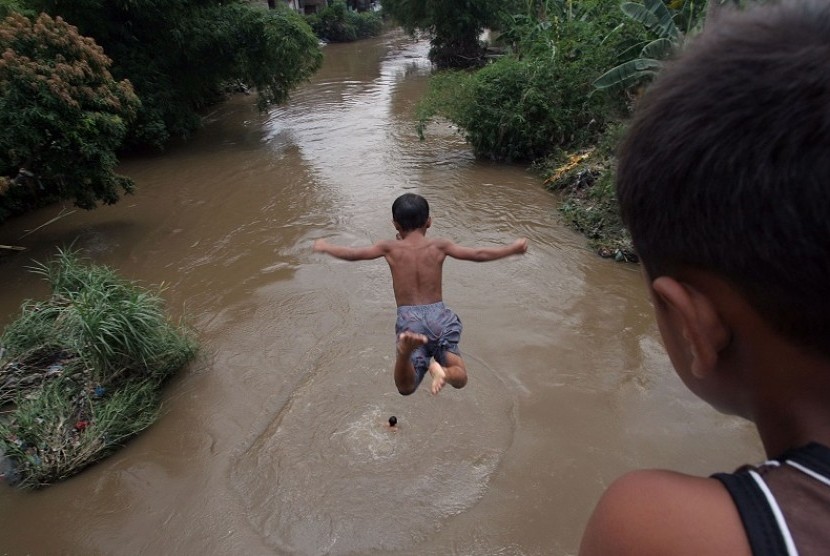 Sejumlah anak bermain dengan melompat dari atas jembatan ke Sungai Deli Medan, Sumut