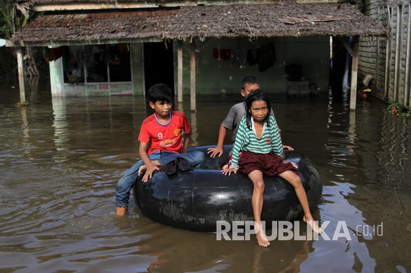 Sejumlah anak bermain di depan rumahnya yang terendam banjir di Desa Rumbia, Kecamatan Bondoala, Konawe, Sulawesi Tenggara, Jumat (17/7/2020). Banjir yang melanda Kecamatan Bondoala sejak pekan lalu tersebut disebabkan meluapnya Sungai Konaweha yang mengakibatkan 303 rumah warga di delapan desa terendam banjir.