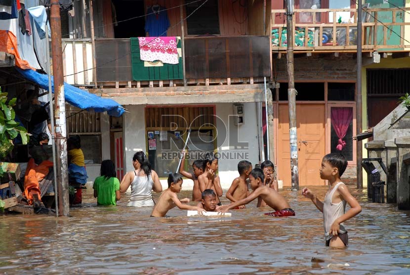  Sejumlah anak bermain di genangan air banjir yang menggenangi kawasan Kampung Melayu Kecil 1, Poncol, Bukit Duri, Jakarta Selatan,Senin (22/10).    (Agung Fatma Putra)