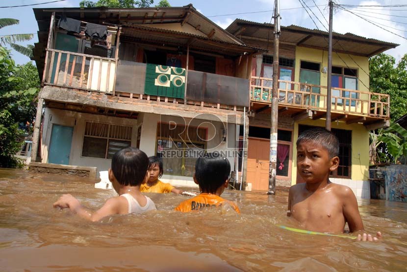  Sejumlah anak bermain di genangan air banjir yang menggenangi kawasan Kampung Melayu Kecil 1, Poncol, Bukit Duri, Jakarta Selatan,Senin (22/10).    (Agung Fatma Putra)