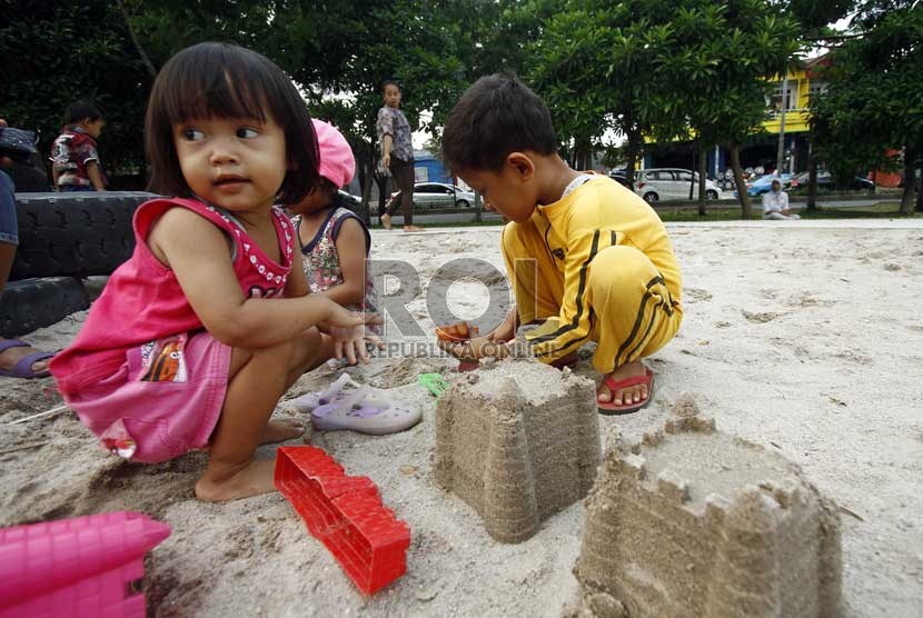   Sejumlah anak bermain patung pasir di taman interaktif di bantaran Kanal Banjir Timur, Duren Sawit, Jakarta Timur, Senin (25/3). 