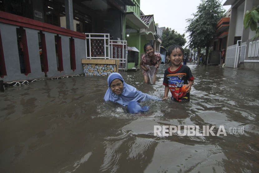 Sejumlah anak bermain saat banjir di kawasan Perumahan Tirta Mandala, Depok, Jawa Barat, Sabtu (15/2/2020). Hujan deras sejak pukul 13.00 mengakibatkan ratusan rumah di Depok terendam banjir.