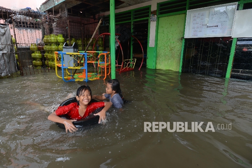  Sejumlah anak bermain saat banjir melanda daerah Kedoya Utara, Kebon Jeruk, Jakarta Barat, Ahad (28/2).  (Republika/Raisan Al Farisi)