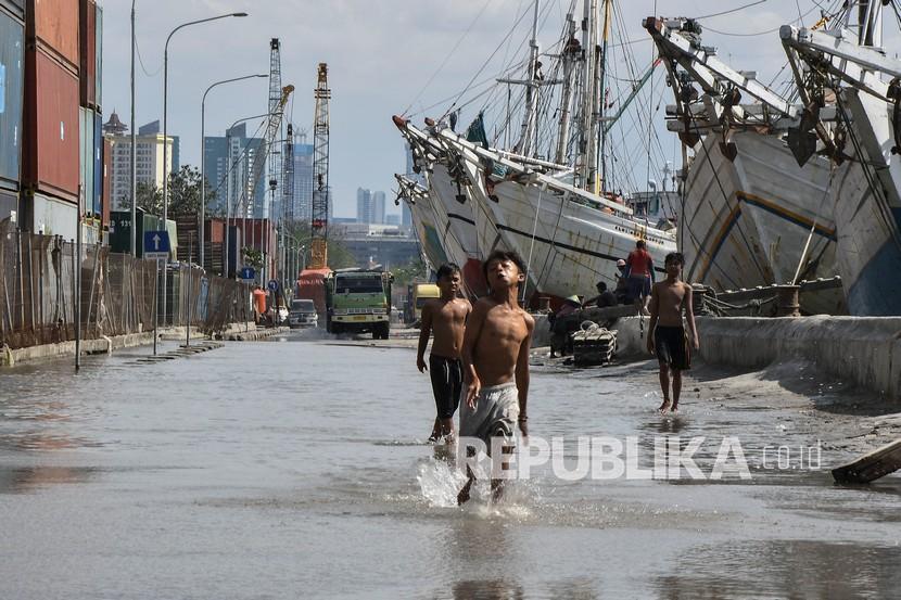 Sejumlah anak bermain saat banjir rob menggenangi Pelabuhan Sunda Kelapa, Jakarta Utara, Sabtu (16/1/2021). Banjir tersebut dikarenakan kenaikan permukaan air laut di pesisir utara Jakarta.
