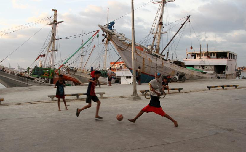 Sejumlah anak bermain sepak bola di dermaga Pelabuhan Rakyat Paotere, Makassar, Sulawesi Selatan. Pelabuhan Makassar mengantisipasi puncak arus balik Nataru pada 13 Januari mendatang.