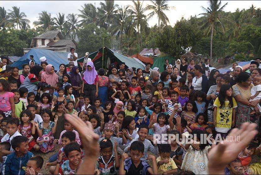 Sejumlah anak bernyanyi bersama dengan relawan di tempat penampungan pengungsi korban gempa bumi di Pemenang, Lombok Utara, Lombok Utara, NTB, Selasa (7/8). Sebanyak 2.935 jiwa korban gempa bumi mengungsi di tempat itu dan diperkirakan akan terus bertambah. 