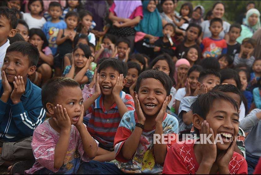 Sejumlah anak bernyanyi bersama dengan relawan di tempat penampungan pengungsi korban gempa bumi di Pemenang, Lombok Utara, Lombok Utara, NTB, Selasa (7/8). Sebanyak 2.935 jiwa korban gempa bumi mengungsi di tempat itu dan diperkirakan akan terus bertambah. 