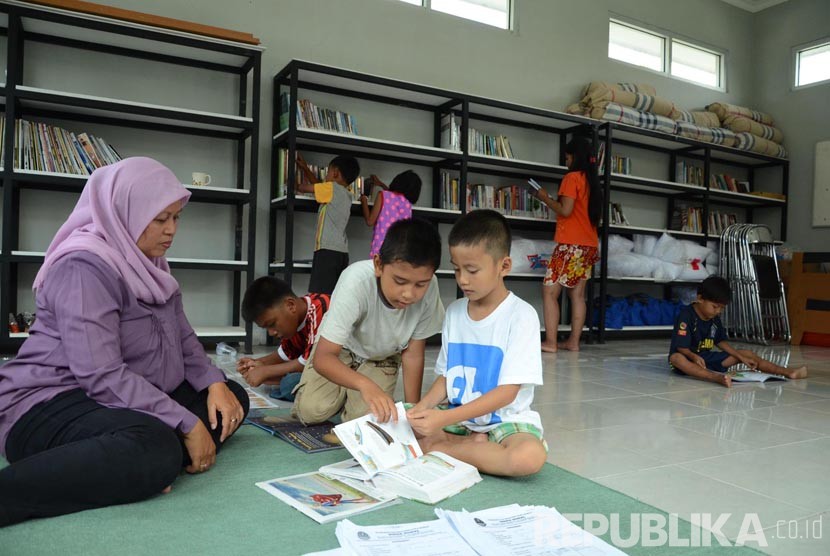 Sejumlah anak dari orang tua eks Gafatar membaca buku ditemani petugas di Perpustakaan Dinas Sosial Jabar, Kota Cimahi, Kota Bandung, Rabu (3/2).
