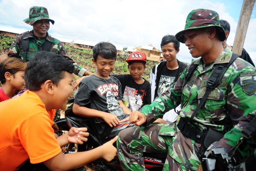 Sejumlah anak dari warga eks Gafatar bermain bersama anggota prajurit Yon 643 Wanara Sakti Anjungan, di pemukiman mereka di kawasan Monton Panjang, Dusun Pangsuma, Desa Antibar, Mempawah Timur, Kabupaten Mempawah, Kalbar, Selasa (19/1). 