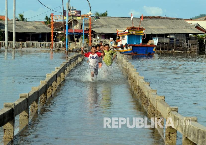 Sejumlah anak melintas di jembatan yang digenangi air saat banjir rob, ilustrasi. Badan Meteorologi Klimatologi dan Geofisika (BMKG) Lampung memprediksi terjadi potensi hujan lebat di sebagian besar wilayah Lampung pada Senin (30/5/2022).